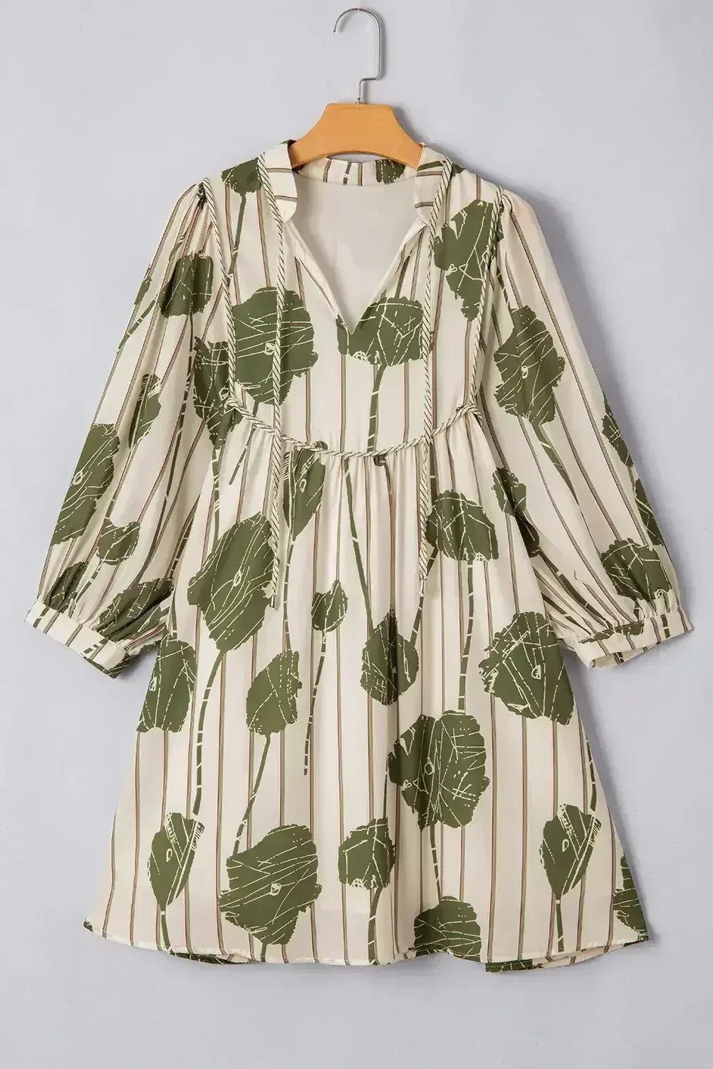 Floral patterned dress on a hanger against a gray background
