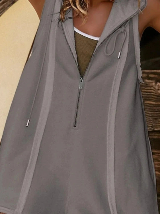 Gray zip-up vest worn by a person, with a blurred background