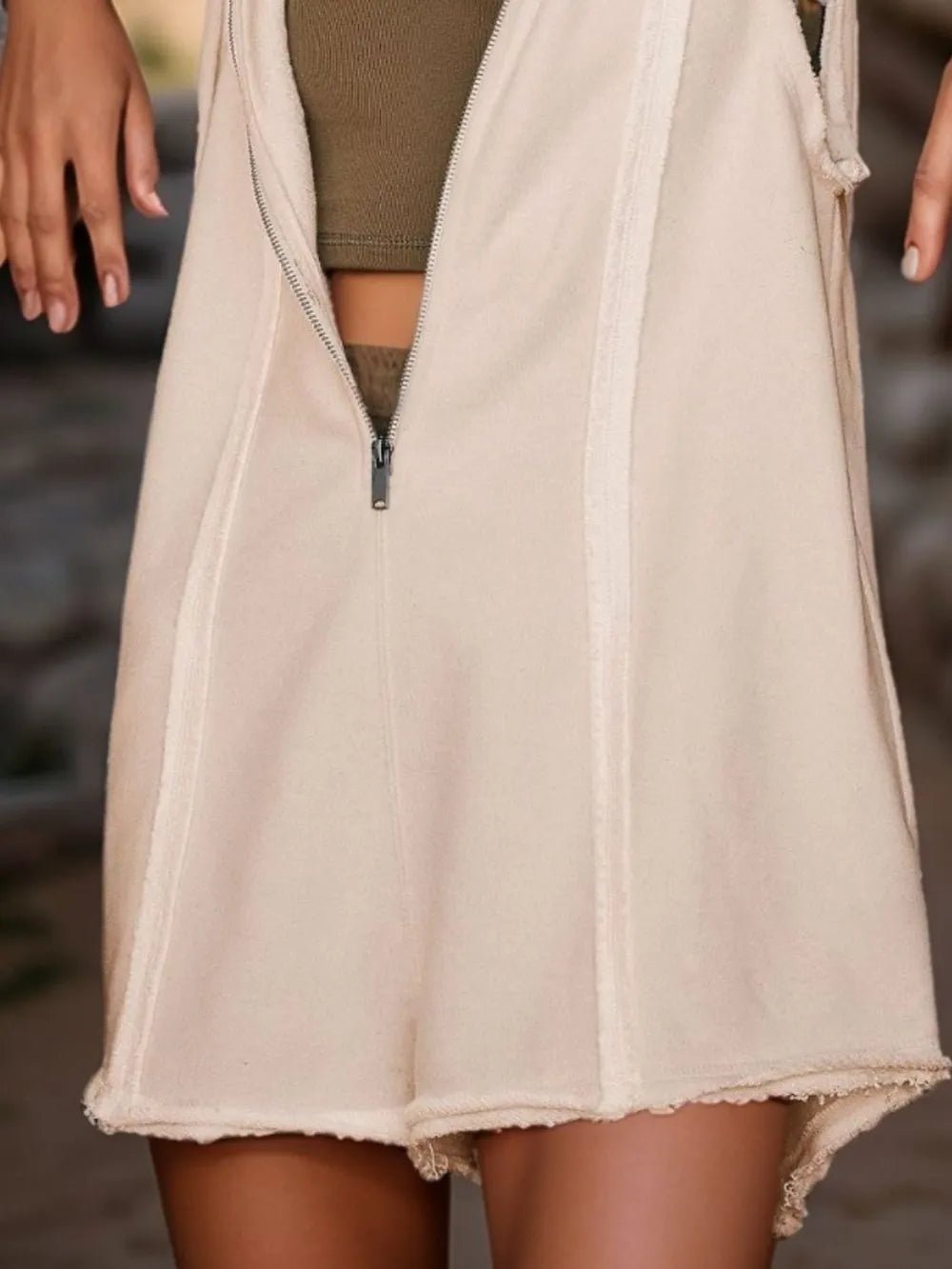 Beige robe with a zipper detail worn by a person, blurred background