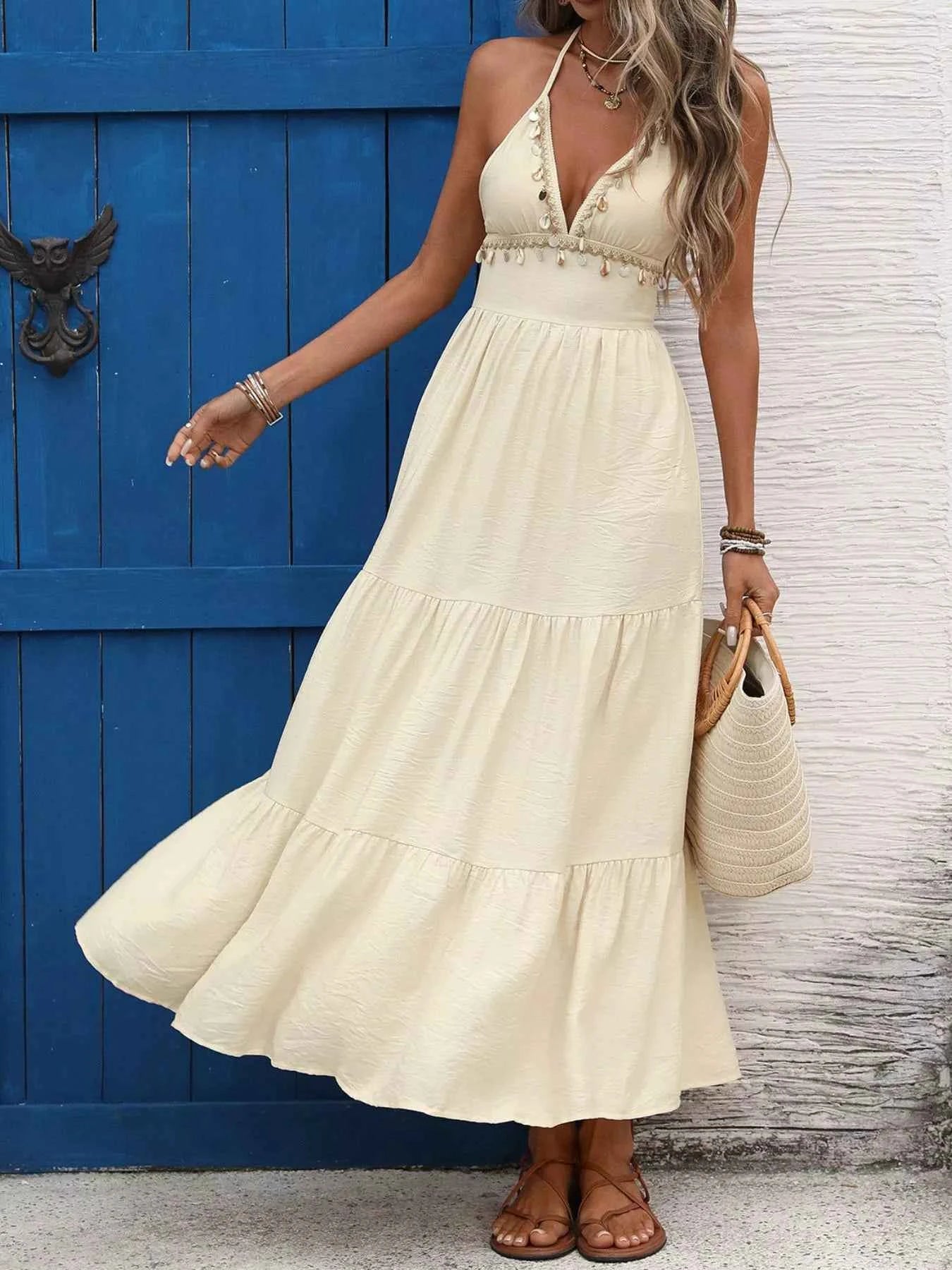 Woman in a white dress standing in front of a blue door.