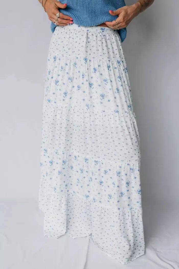 White floral skirt worn by a person on a plain background