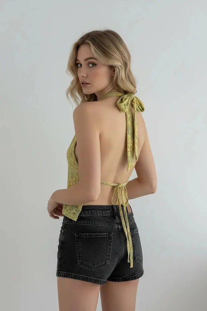 Back view of yellow green floral lace halter top with tied straps