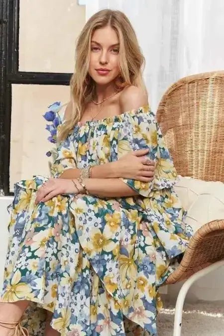 Woman wearing a floral off-shoulder dress sitting on a wicker chair.