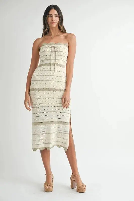 Woman wearing a strapless, patterned dress on a white background