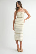 Woman wearing a strapless, patterned dress on a white background