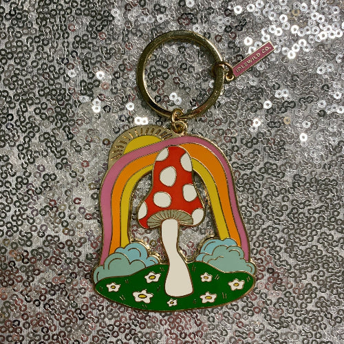Keychain with mushroom and rainbow design on a glittery background