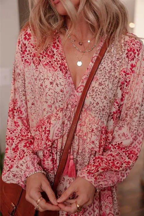 Detailed texture shot of red and pink floral print on cream viscose fabric