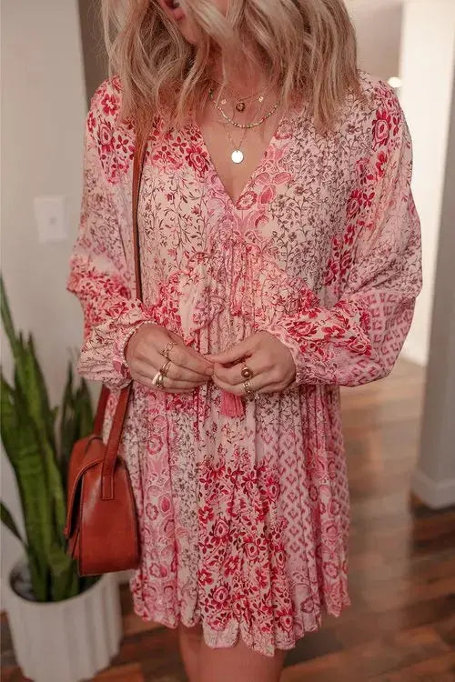Close-up of pink tassel tie and floral geometric pattern on boho mini dress