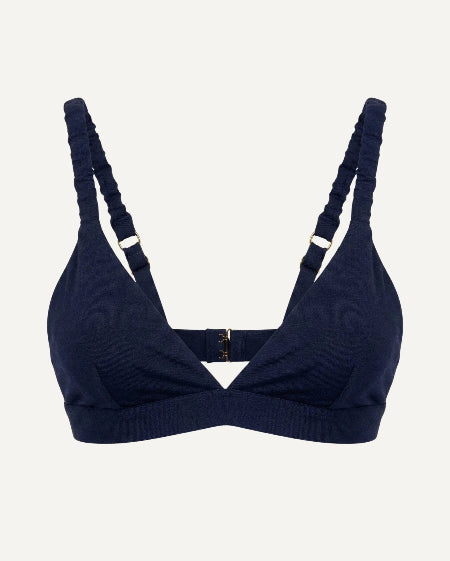 Navy blue bikini top with thin straps on a light gray background