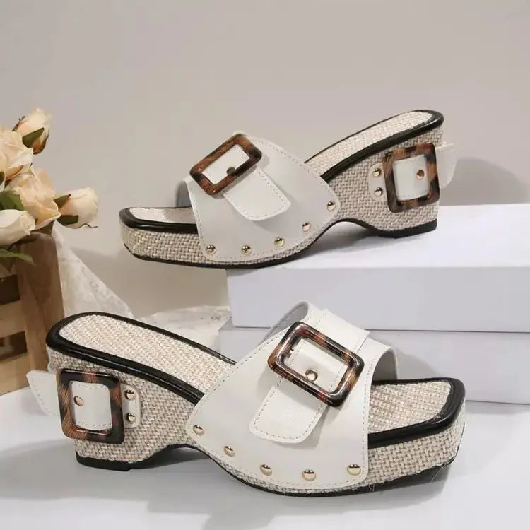 White open toe wedge sandals with tortoiseshell buckle on display