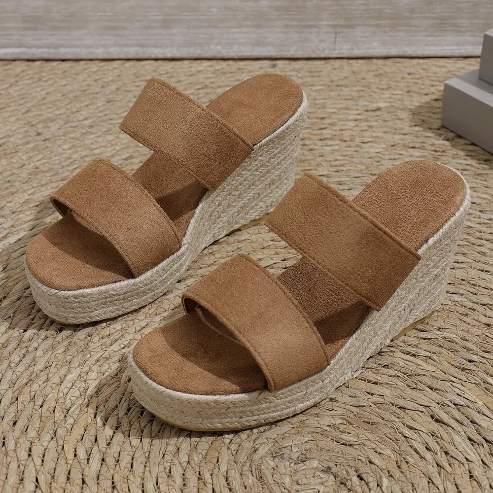 Brown wedge sandals with espadrille sole on a woven mat
