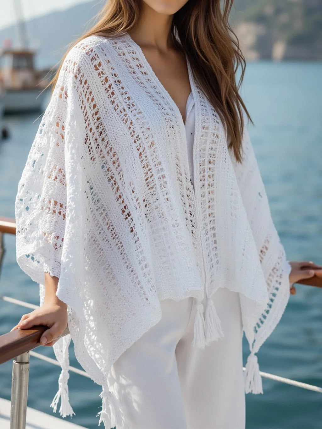 Person wearing a white lace cover-up by the water