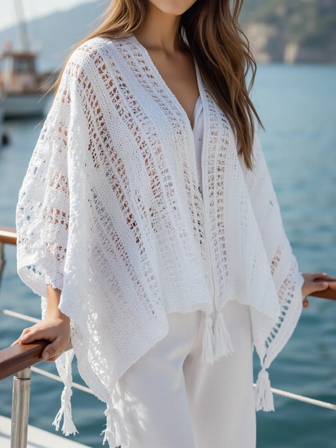 Person wearing a white lace cover-up by the water