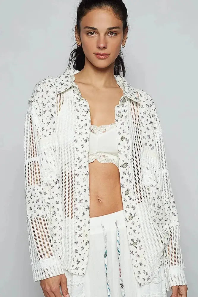 Woman wearing a white crochet top with floral patterns on a gray background