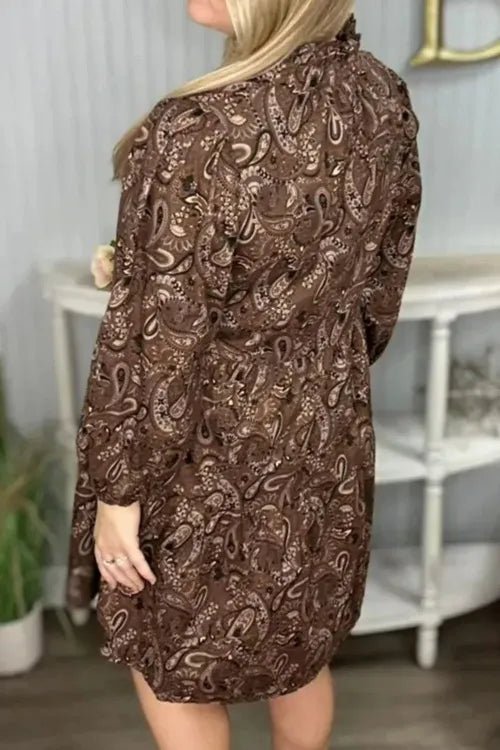 Brown patterned dress worn by a person indoors with a neutral background