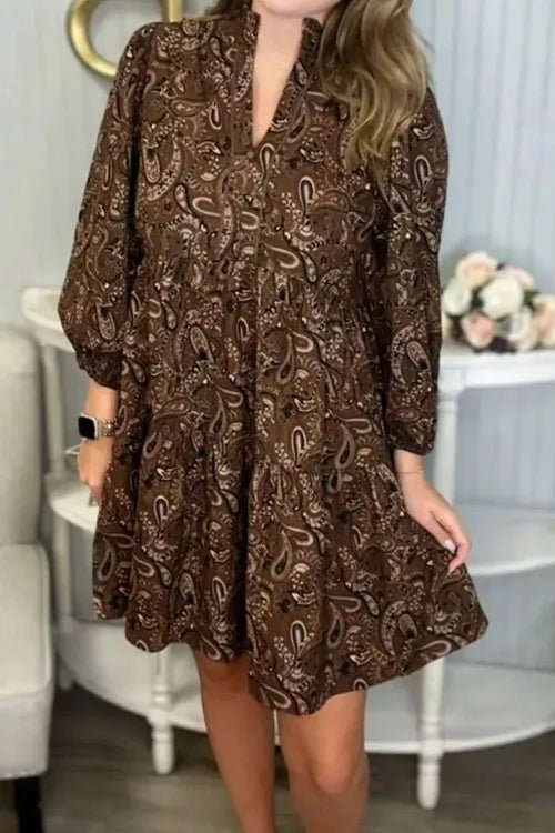Woman wearing a brown patterned dress in an indoor setting.