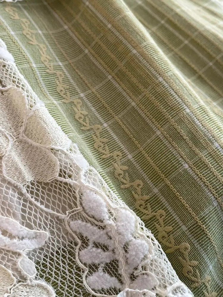 Close-up of green fabric with lace detailing