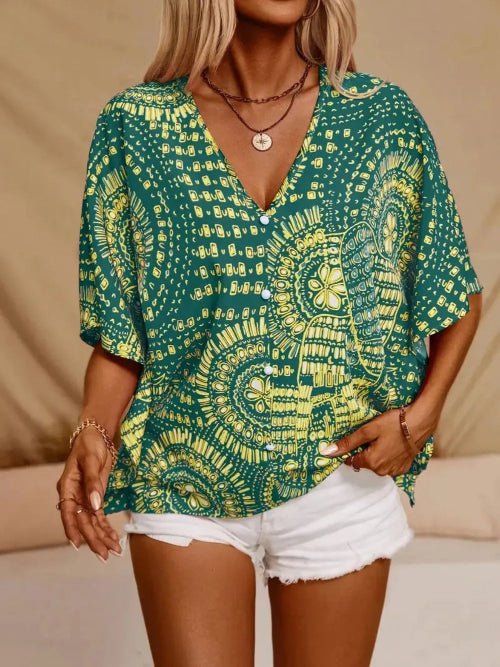Person wearing a green and yellow patterned top with white shorts on a beige background