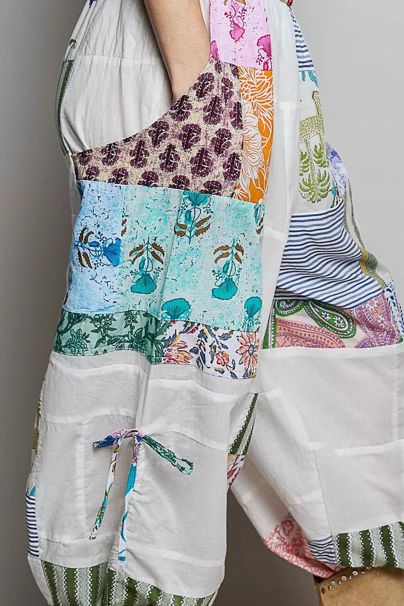 Colorful patchwork dress with floral and abstract patterns on a plain background