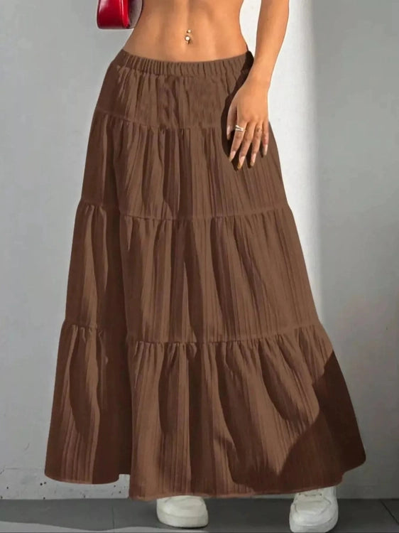 Brown tiered maxi skirt with shadow on white wall