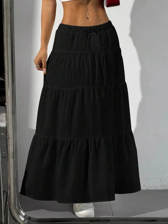Black tiered maxi skirt with shadow on white wall