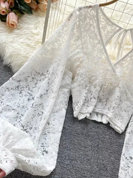 White lace fabric on a textured surface with flowers in the background