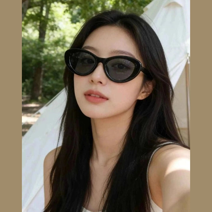 Black retro cat eye sunglasses with dark lenses on model outdoors
