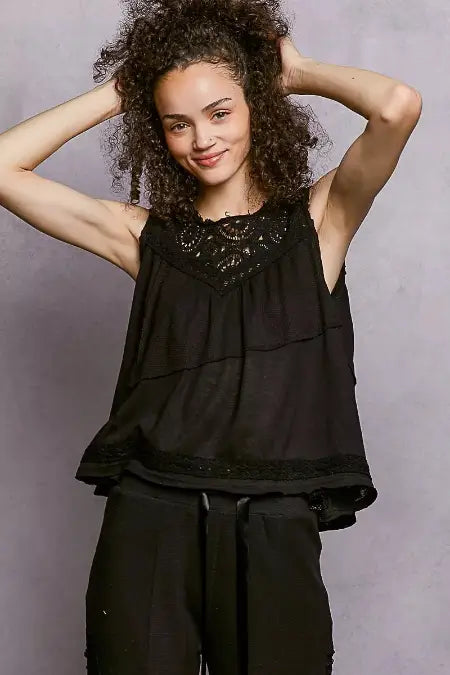 Woman wearing a black sleeveless top against a gray background