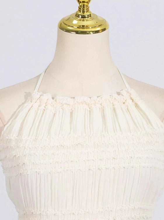 White dress on a mannequin with a gold top against a white background