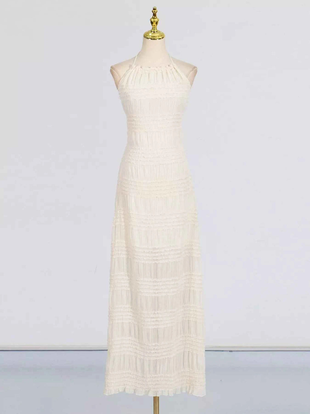 White lace dress on a mannequin against a plain background