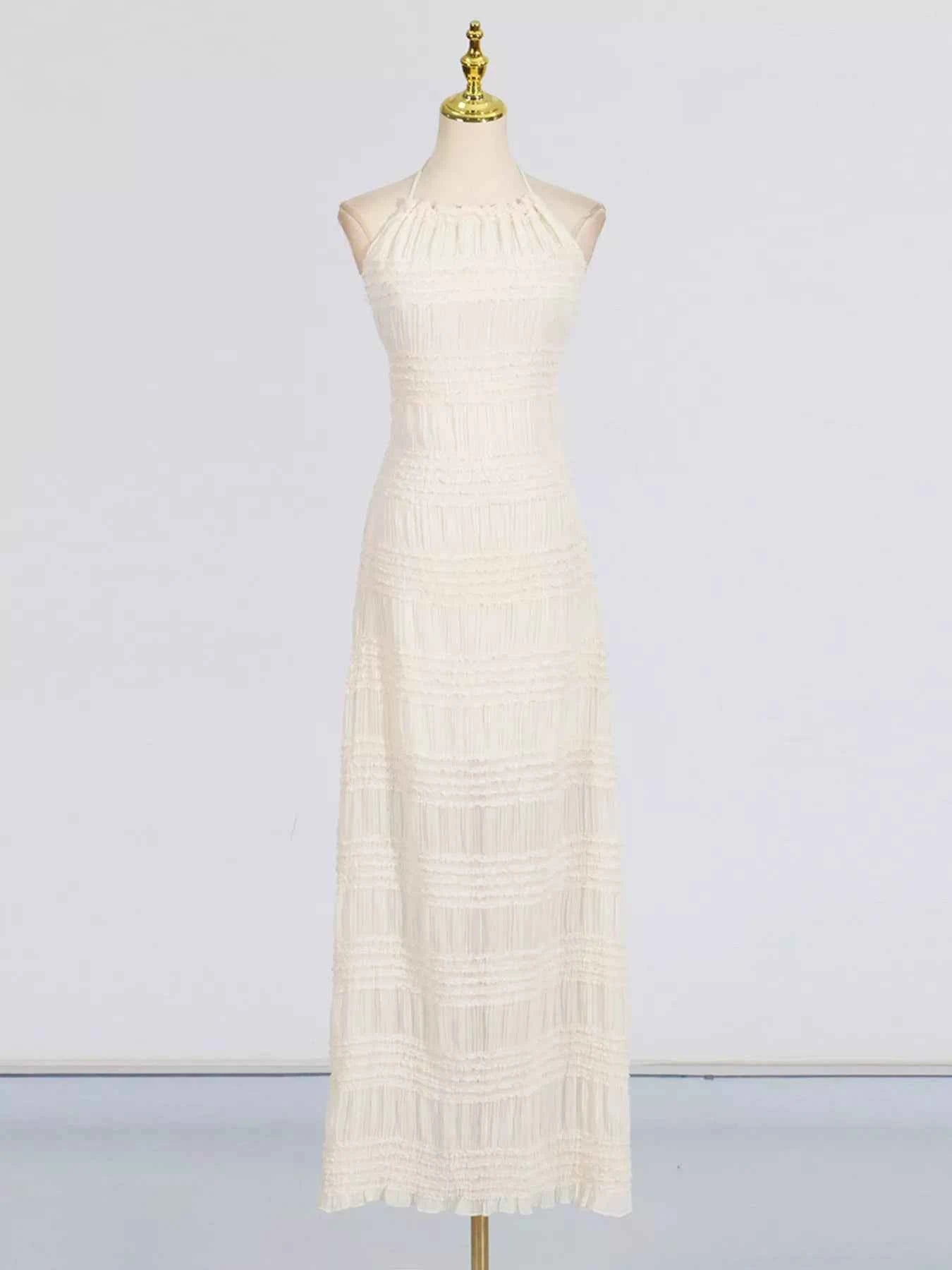 White lace dress on a mannequin against a plain background