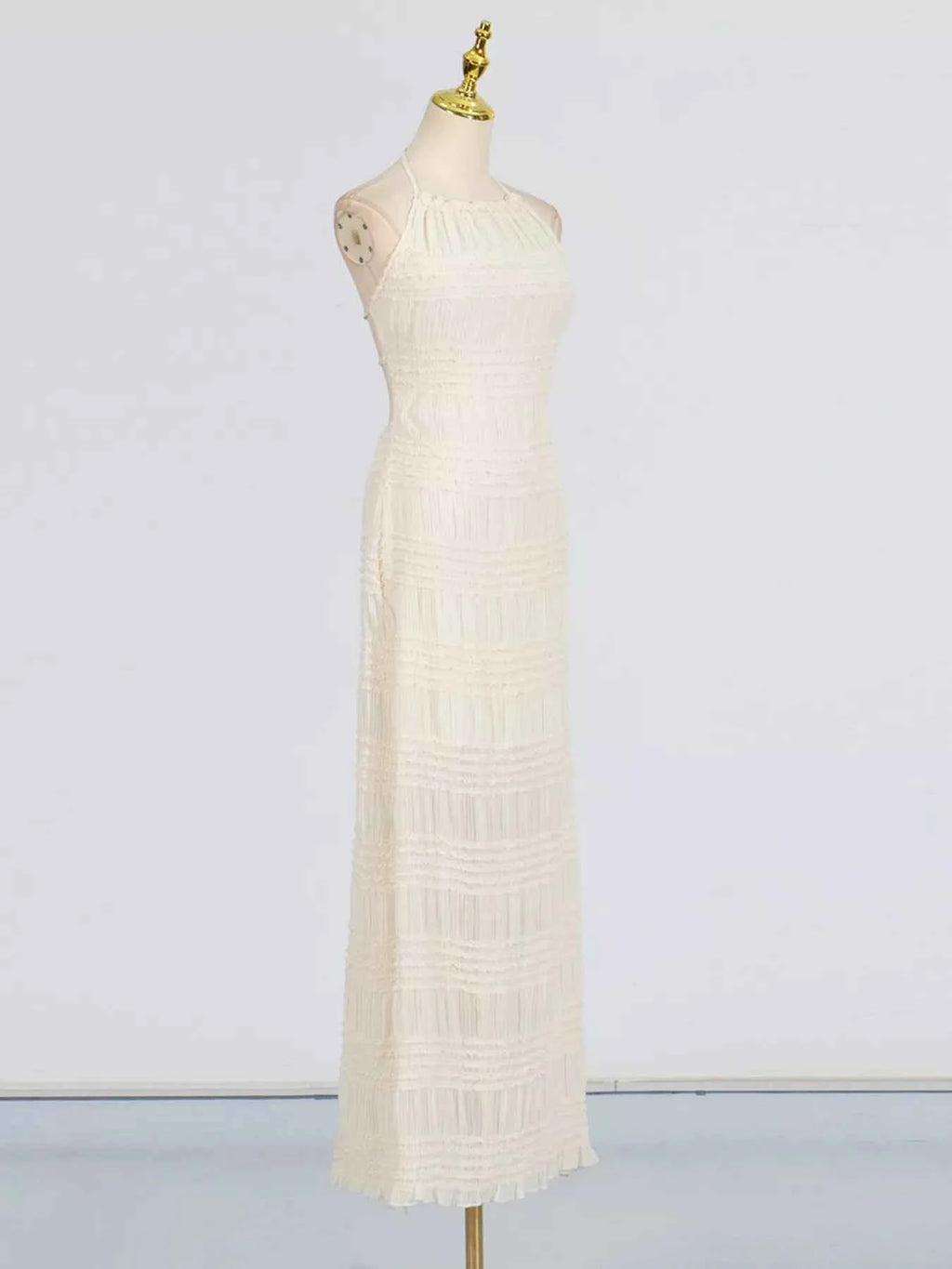 White dress on a mannequin against a plain background