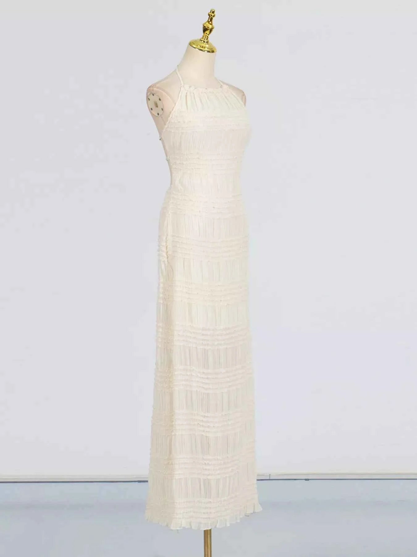 White dress on a mannequin against a plain background