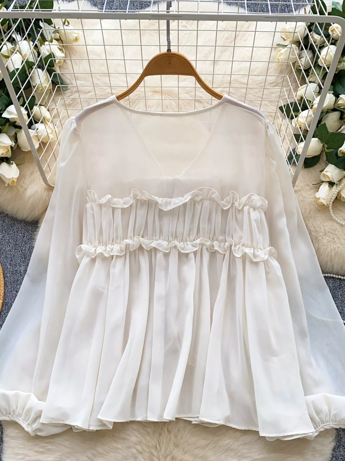 White lace dress on a hanger with a floral background