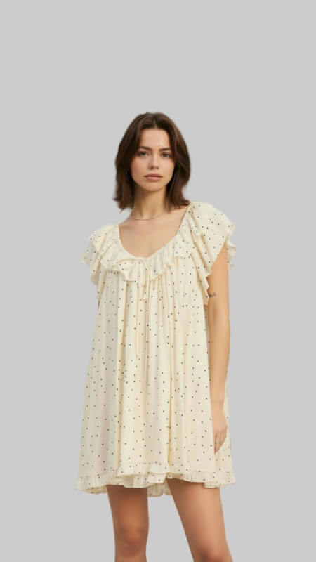 Woman wearing a light yellow dress with a subtle pattern on a earth toned background