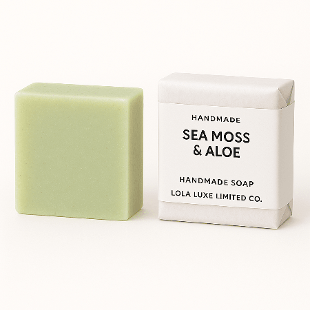 Bar of sea moss and aloe handmade soap next to its packaging on a white background