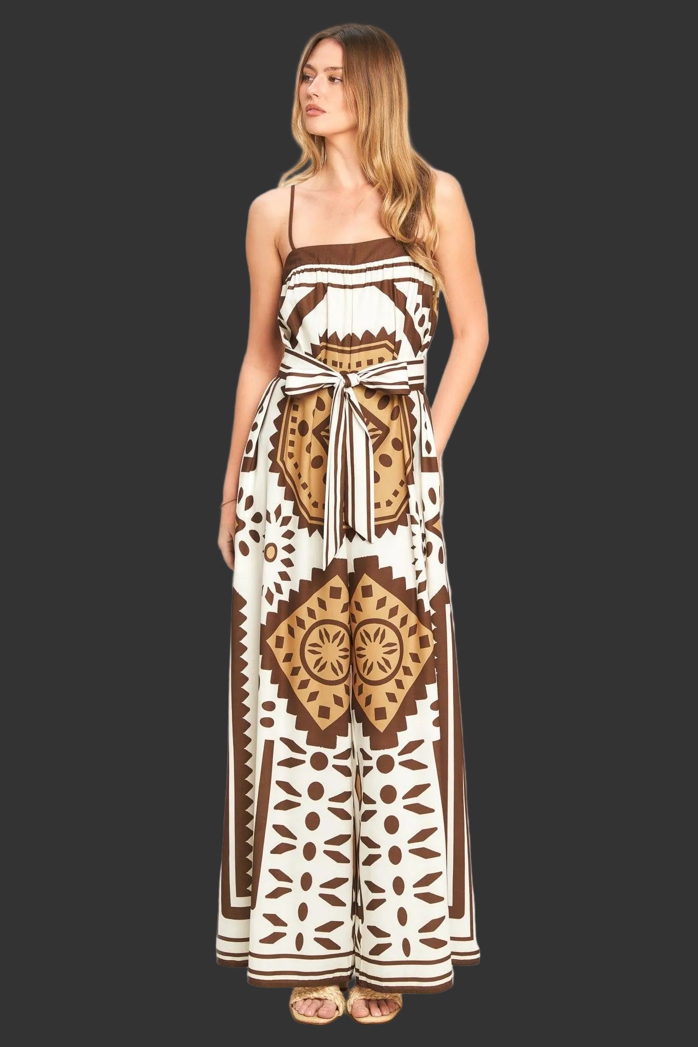 Woman wearing a long, patterned dress against a plain background