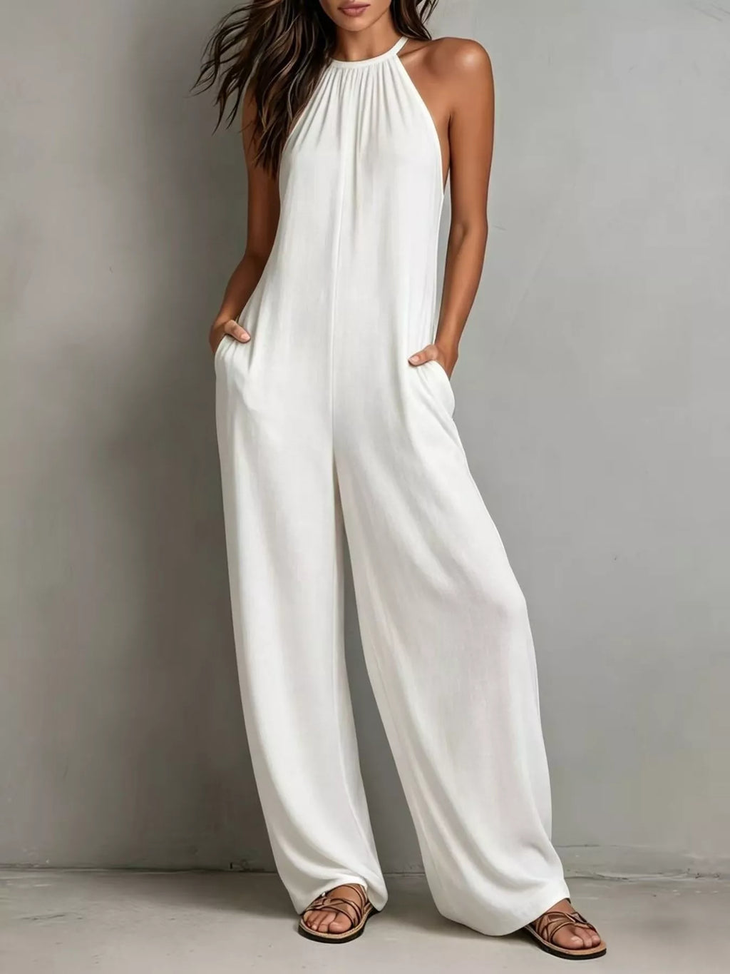 Woman wearing a white jumpsuit against a plain background