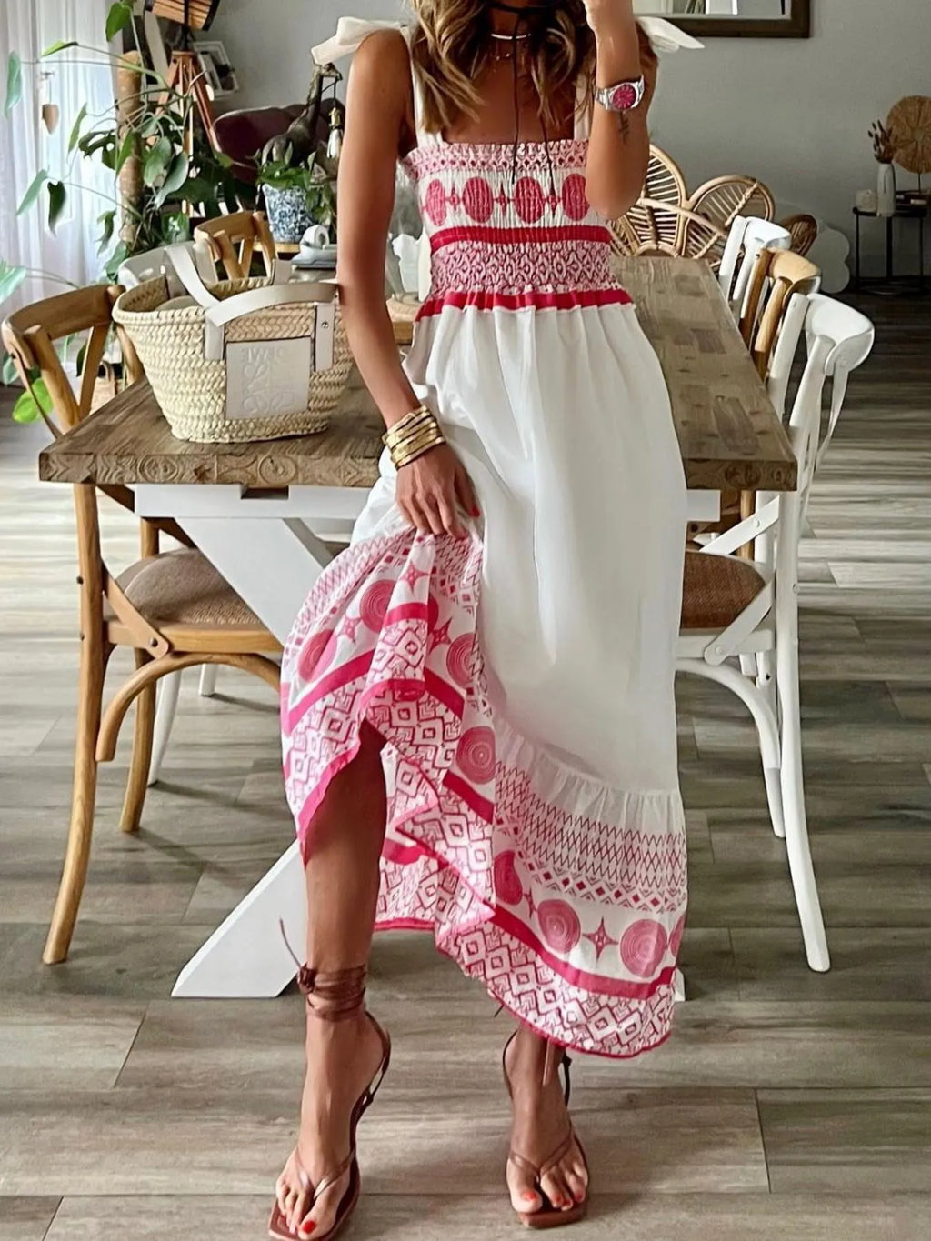 Woman wearing a pink and white dress standing in a dining room.