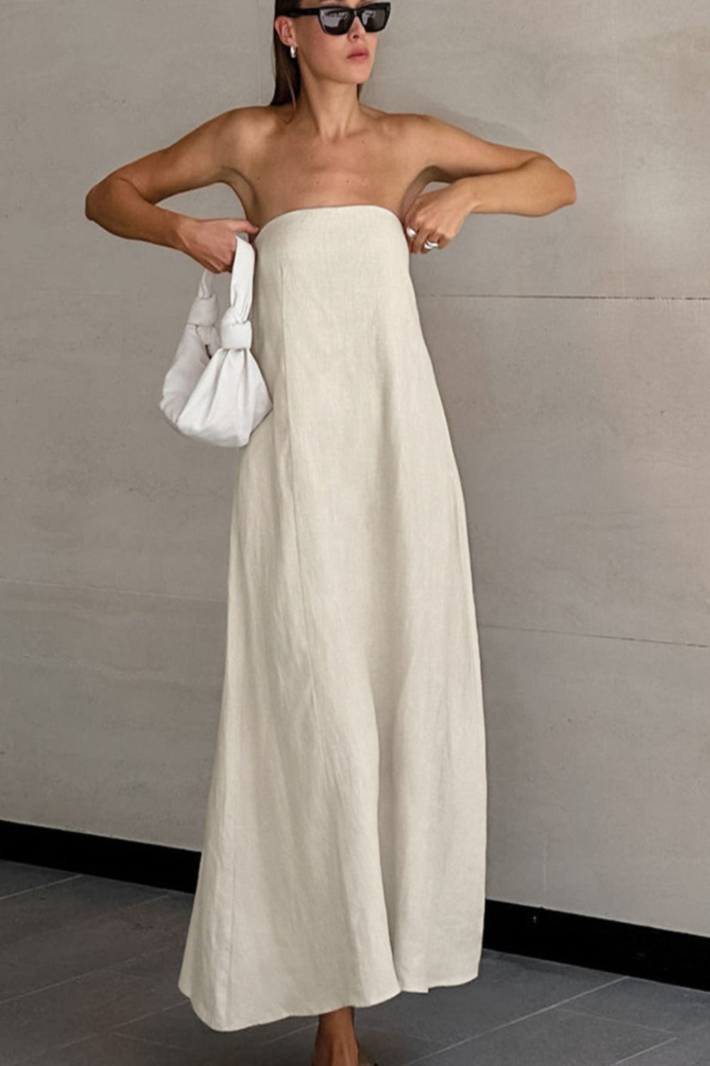 Smocked Back Tube Dress - Salty Season LLC Woman wearing a strapless white dress holding a white handbag against a plain background