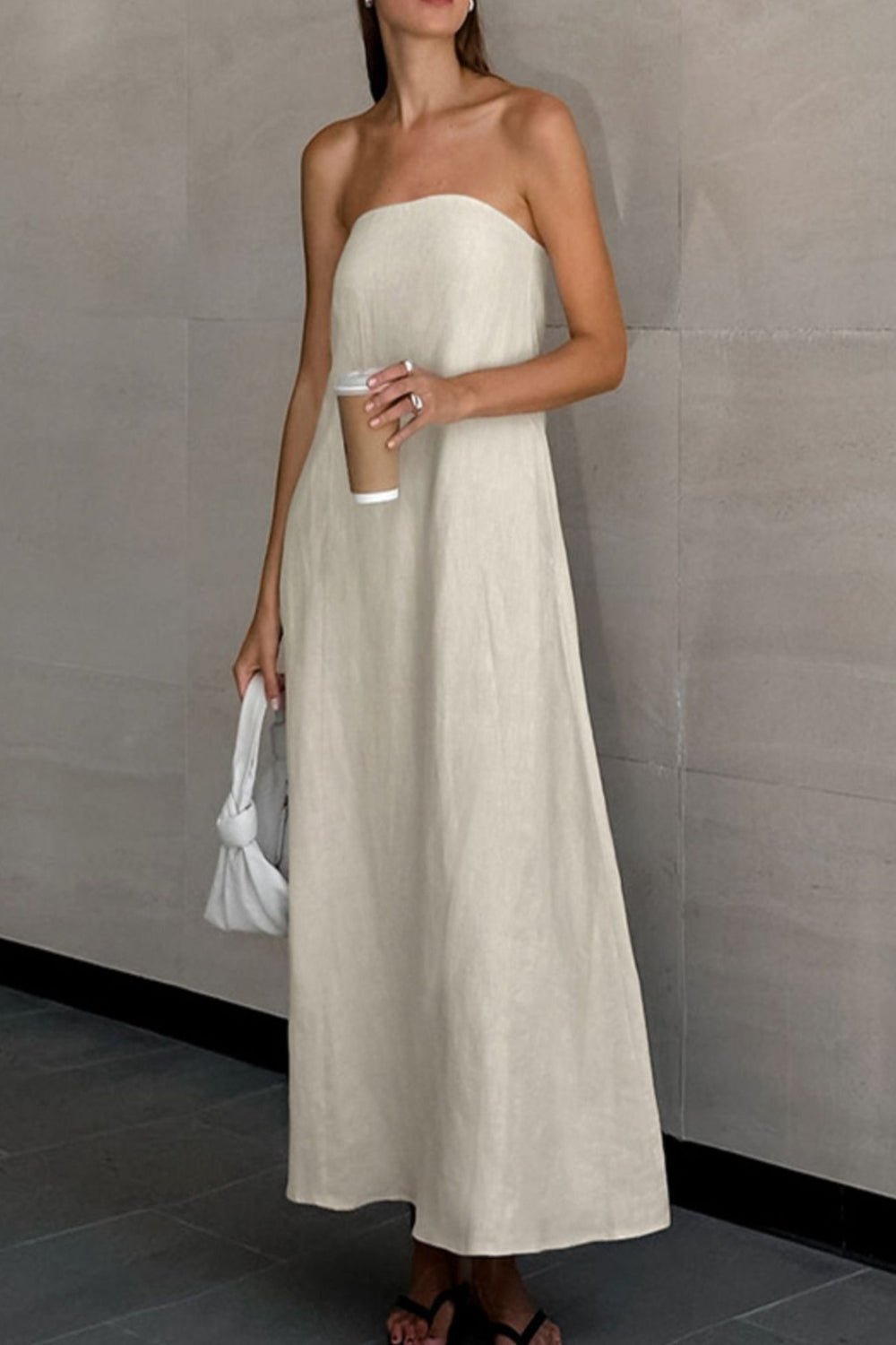 Smocked Back Tube Dress - Salty Season LLC Woman wearing a strapless beige dress holding a coffee cup against a plain background