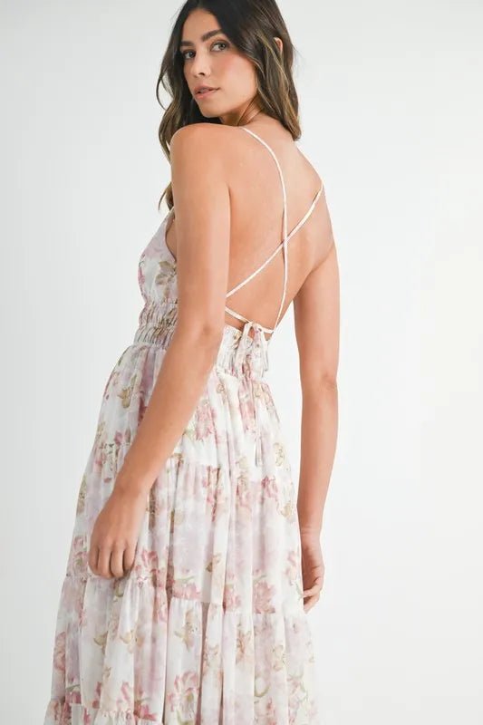 Woman wearing a floral dress with thin straps on a white background