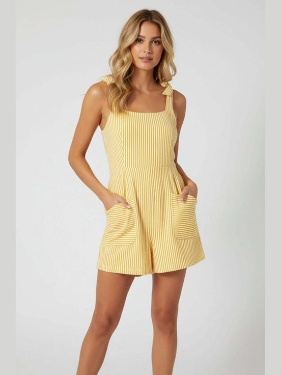 Yellow striped romper on blonde woman against a white background