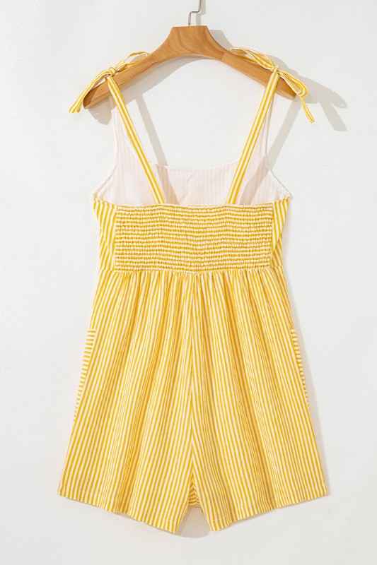 Yellow striped romper on a hanger against a white background