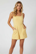 Yellow striped romper on blonde woman against a white background