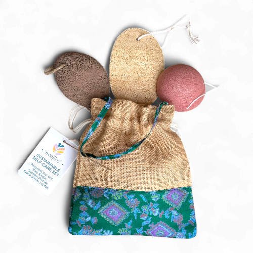 Sustainable soap cake set with natural loofah, bath bomb, and drawstring bag on a white background.