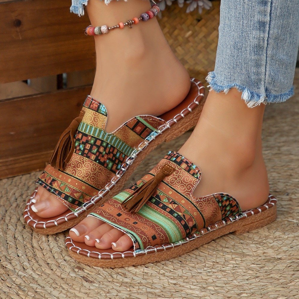 Patterned sandals worn on a foot with a wooden background