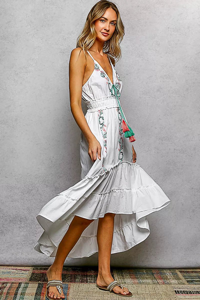 Woman wearing a white floral dress against a gray background
