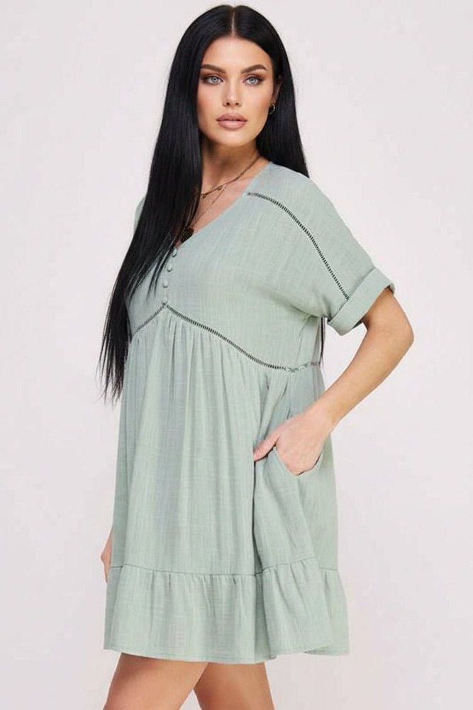 Woman wearing a light green dress with a plain background