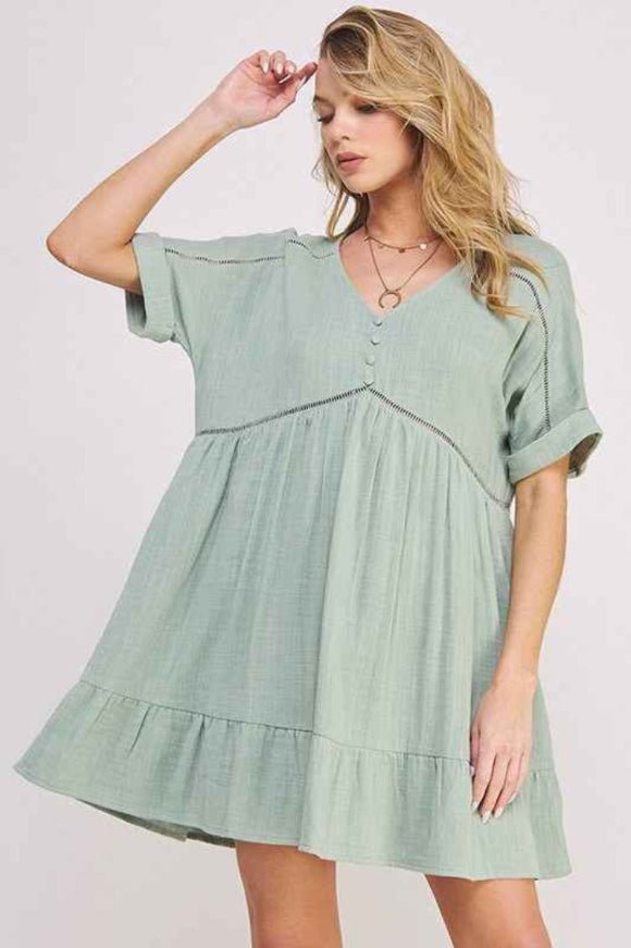 Woman wearing a light green dress with a plain background